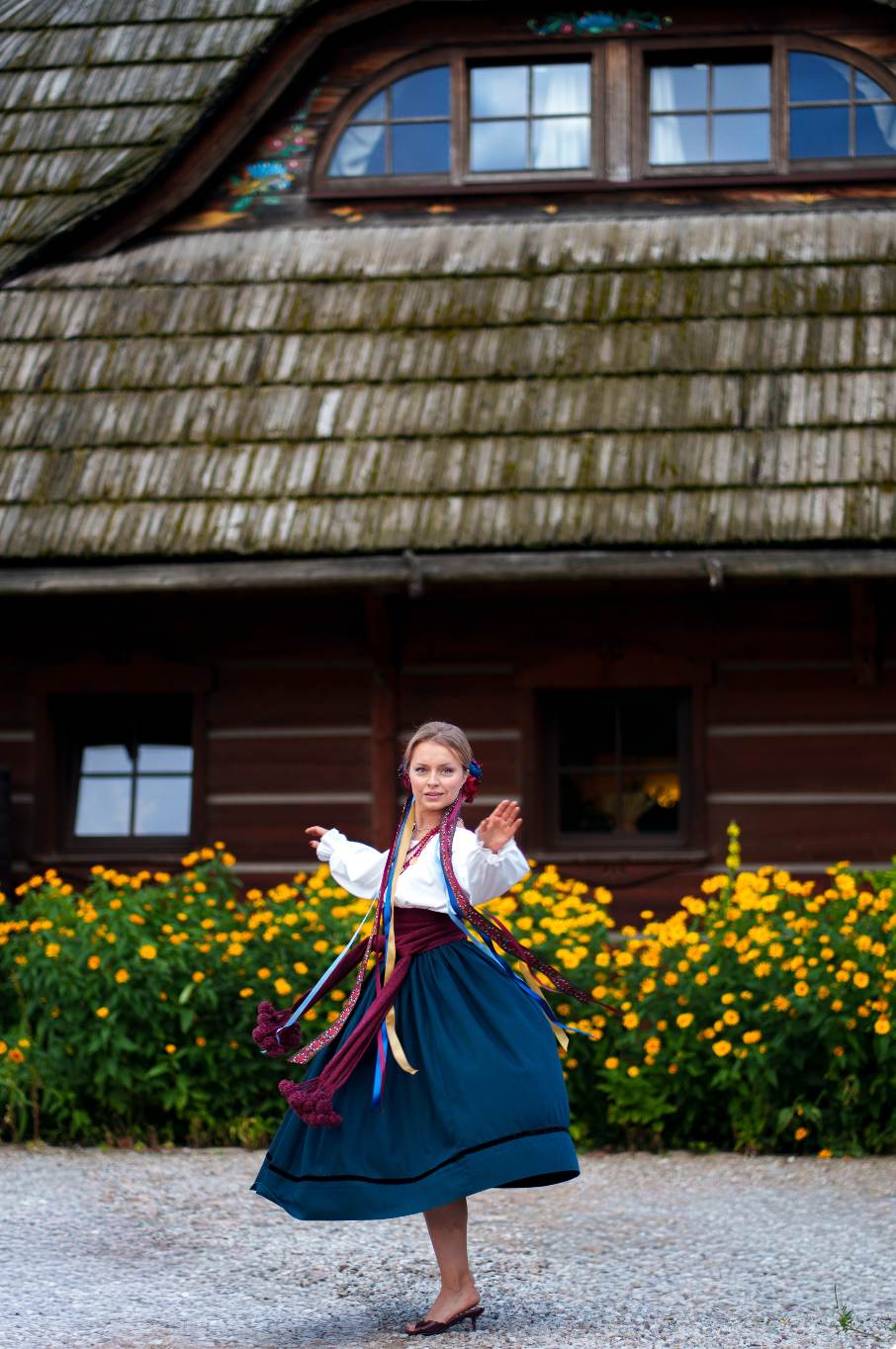 Daria dancing in front of a wooden house